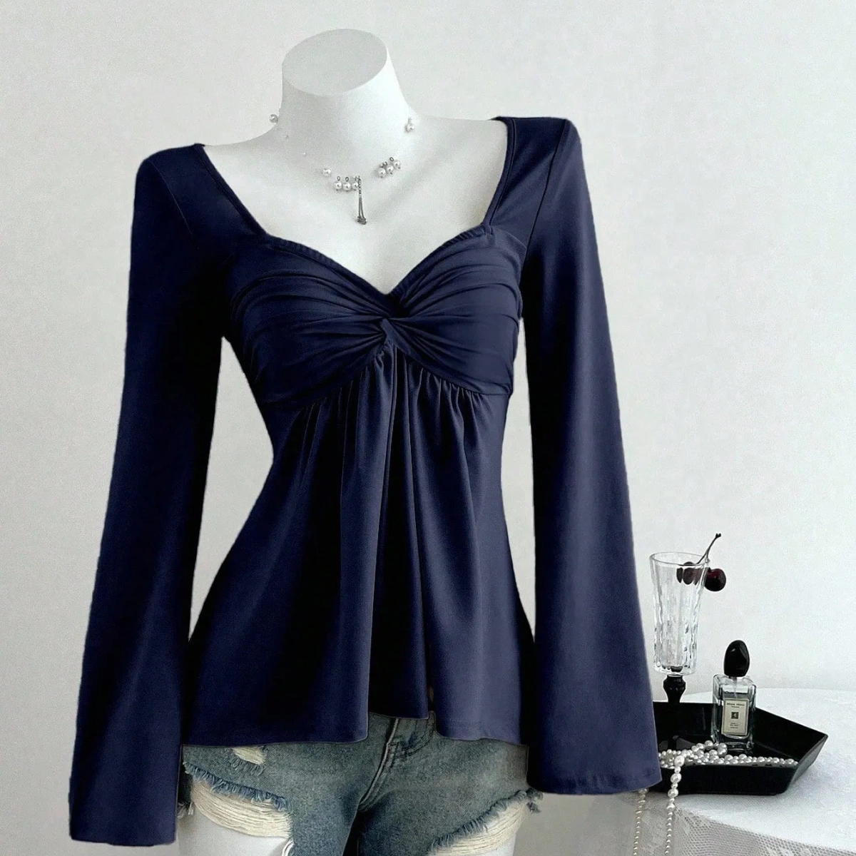 Blusa manga larga con escote descubierto y nudo delantero